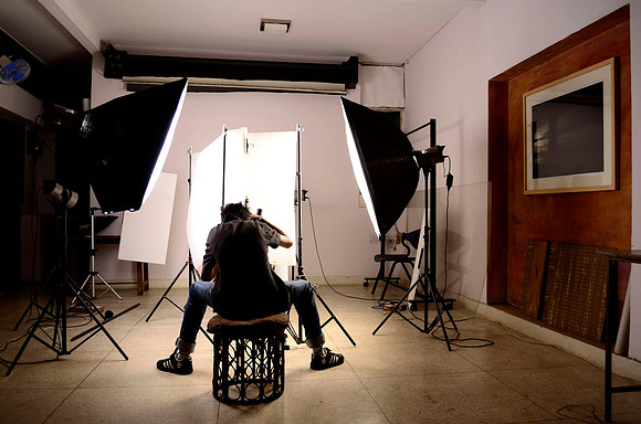 One of the students shooting a highly reflective product in a light tent at the studio.